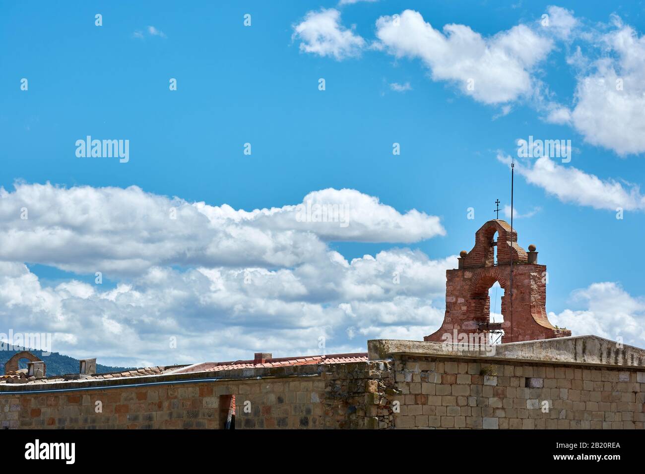 View of the top of the Church of Saint Mary in the medieval city of Montblanc, in the province of Tarragona, Spain. Blue sky with clouds behind. Stock Photo