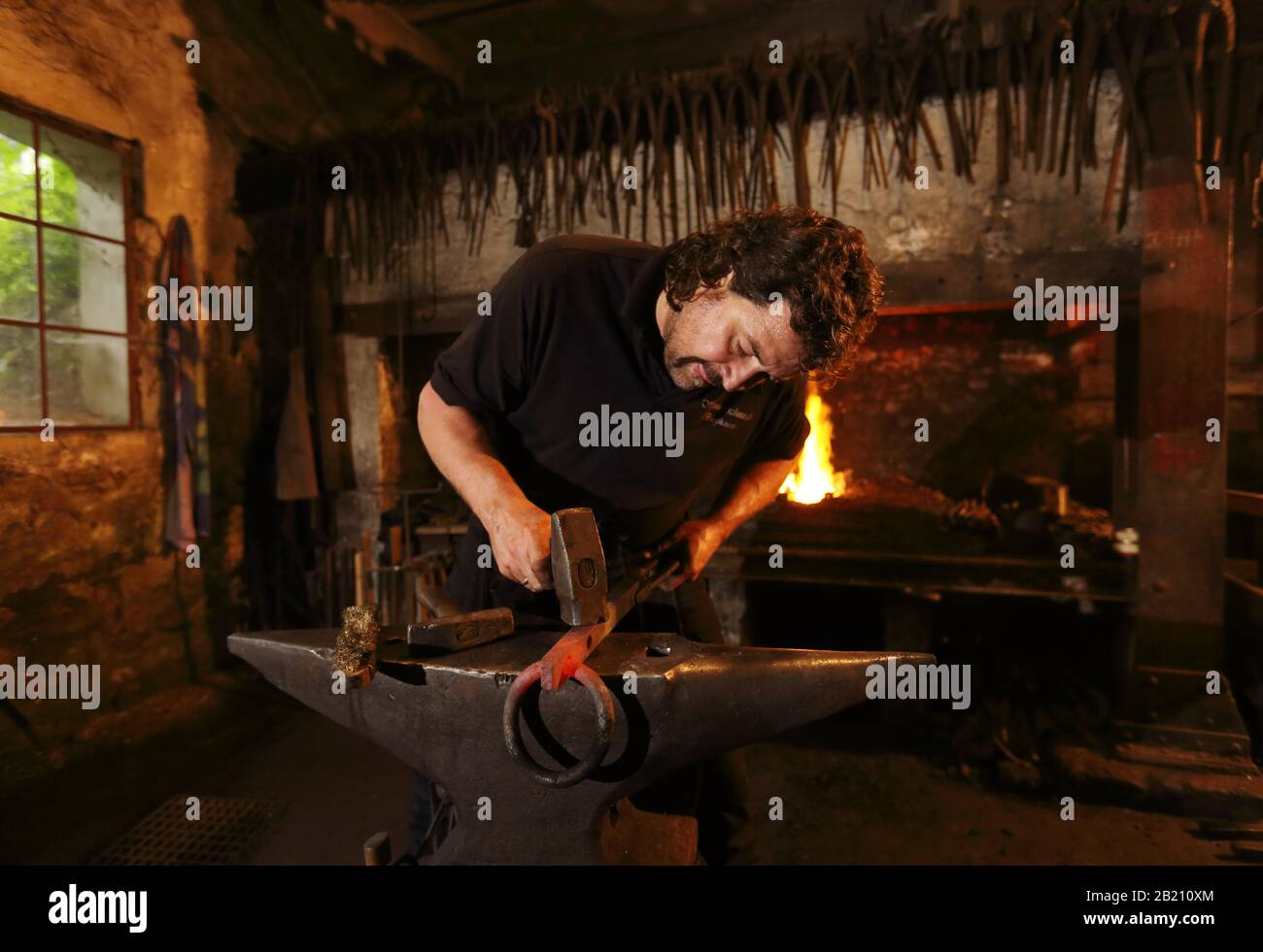 Blacksmith at the anvil, hammer mill Burghausen, Upper Bavaria, Bavaria, Germany Stock Photo