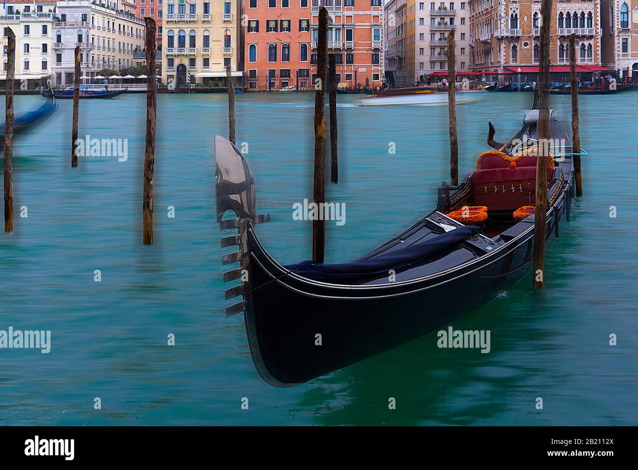Gondola tied to piles on the Grand Canal, behind house facades, Venice, Veneto, Italy Stock Photo