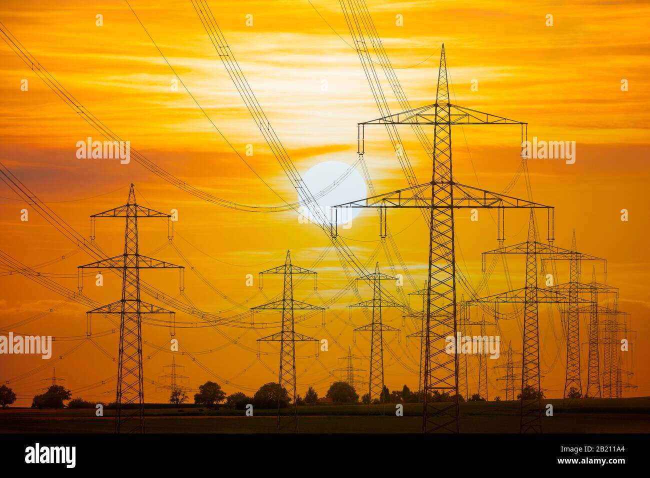 Overhead power lines, high voltage pylons, power lines, setting sun