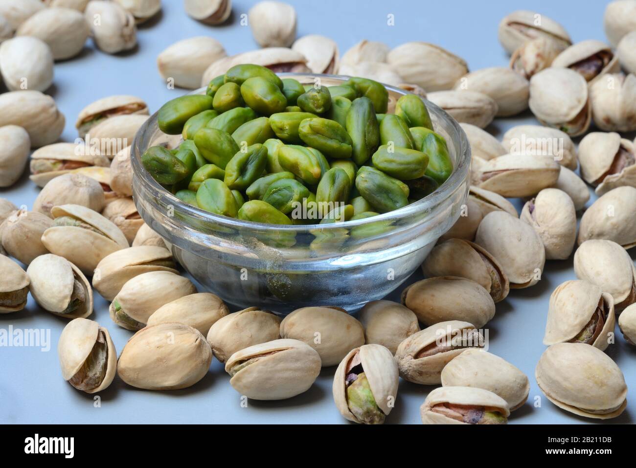 Pistachios in small bowls and roasted pistachios hires stock