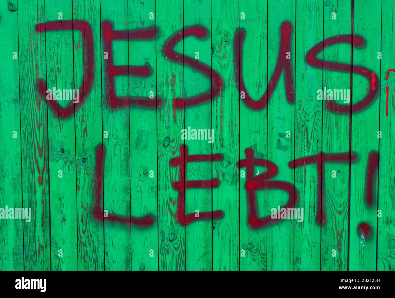 Writing Jesus lives, on a building fence, Berlin, Germany Stock Photo