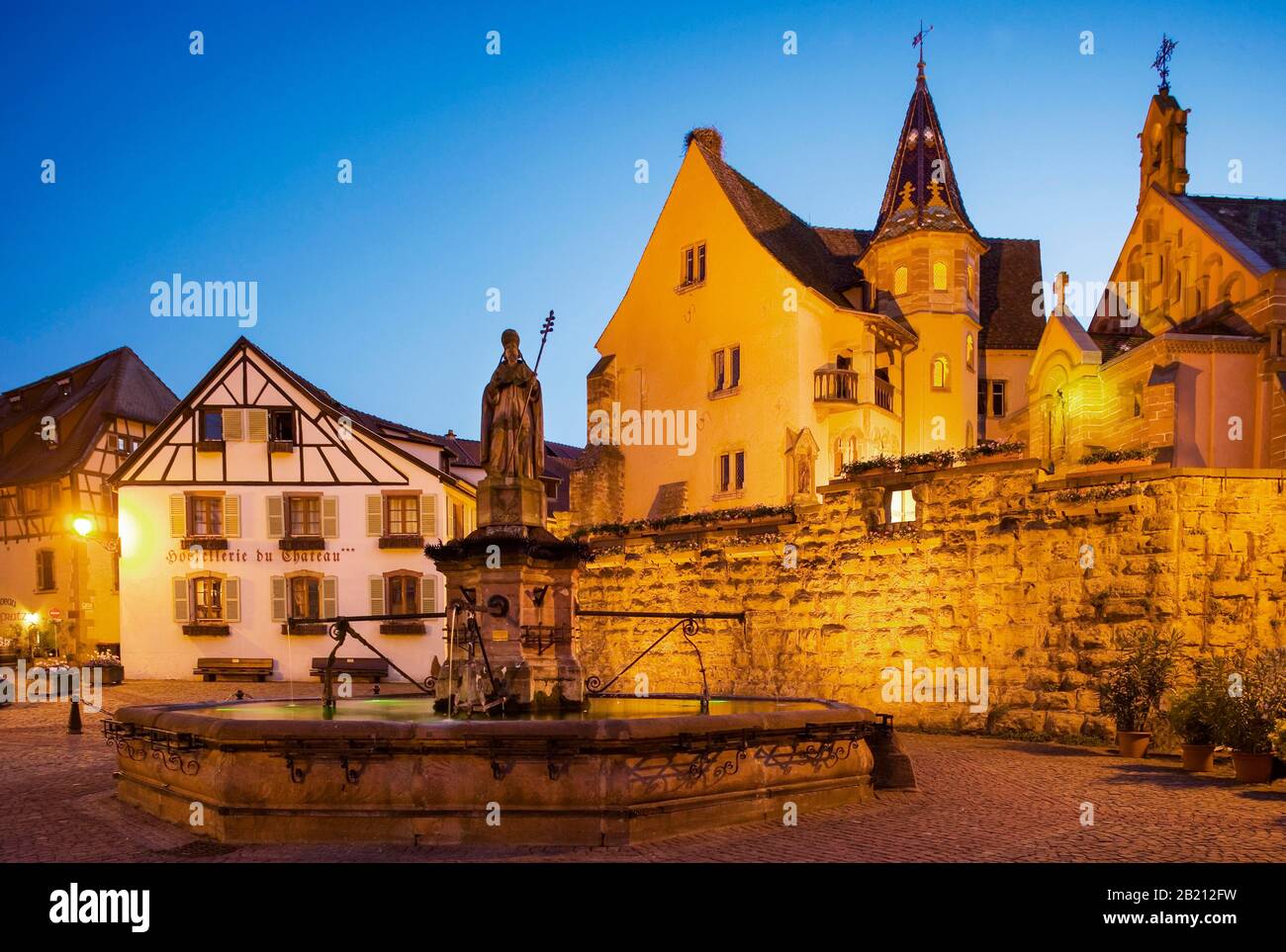 Place de Chateau Saint Leon with Castle of the Dukes of Eguisheim and Leo chapel at dusk, Eguisheim, Alsace, France Stock Photo