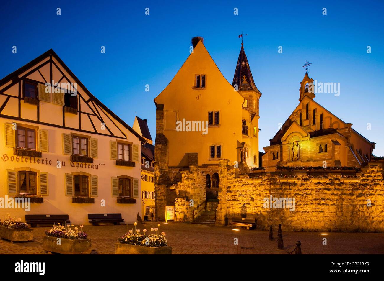 Place de Chateau Saint Leon with Castle of the Dukes of Eguisheim and Leo chapel at dusk, Eguisheim, Alsace, France Stock Photo