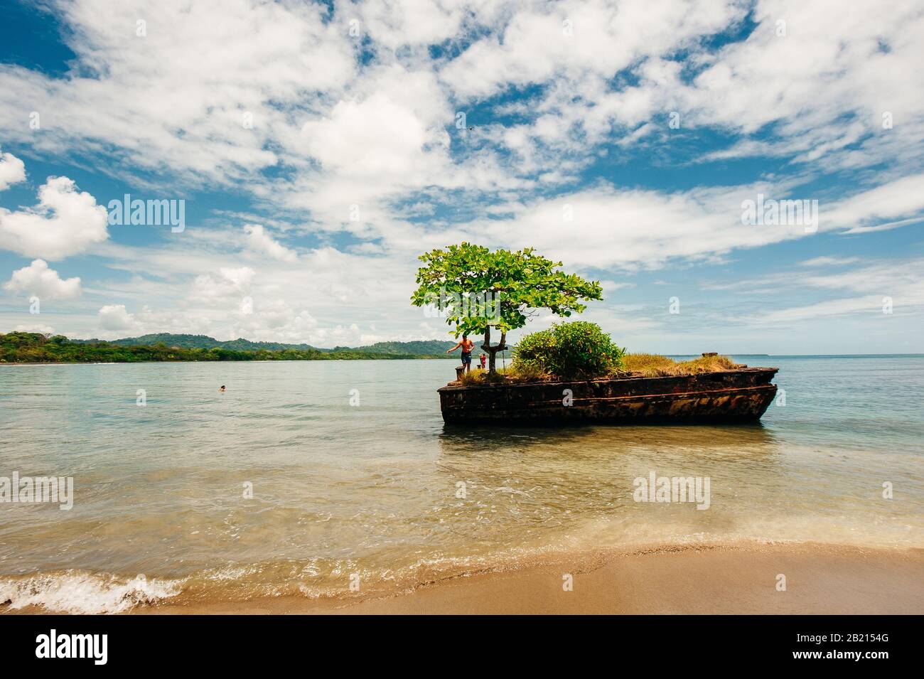 Dock surrounded by water with tree on top at Playa Negra, Puerto Viejo de Talamanca, Costa Rica Stock Photo