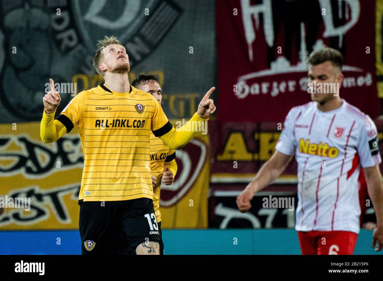 28 February 2020, Bavaria, Regensburg: Football: 2nd Bundesliga, Jahn Regensburg - Dynamo Dresden, 24th matchday in the Continental Arena. Simon Makienok Christoffersen from Dynamo Dresden (l) cheers for his goal to make it 1-2. On the right is Benedikt Saller from Regensburg. Photo: Matthias Balk/dpa - IMPORTANT NOTE: In accordance with the regulations of the DFL Deutsche Fußball Liga and the DFB Deutscher Fußball-Bund, it is prohibited to exploit or have exploited in the stadium and/or from the game taken photographs in the form of sequence images and/or video-like photo series. Stock Photo