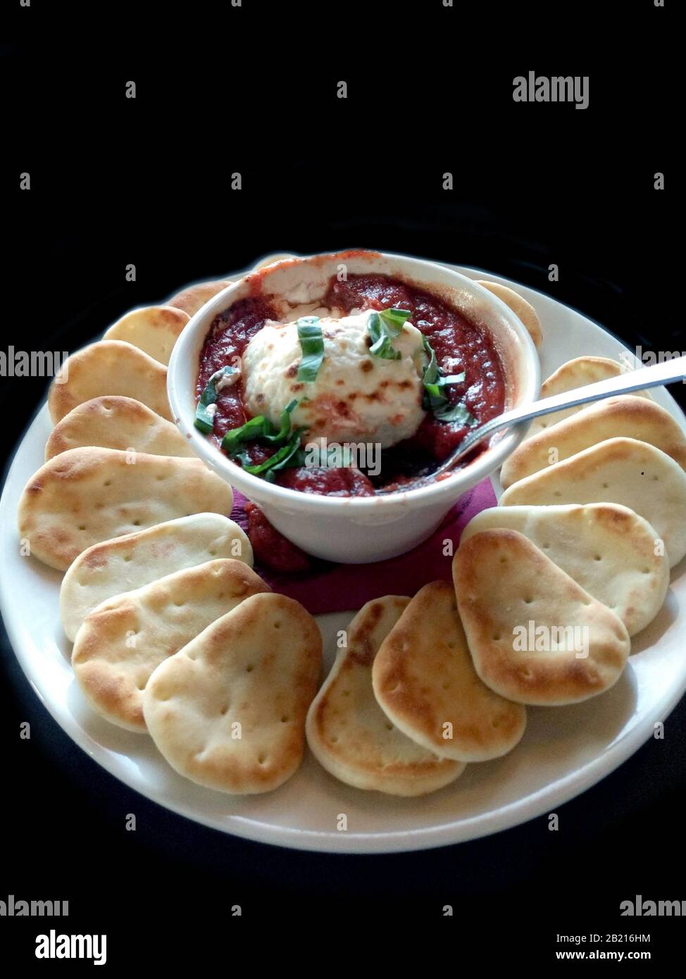 Creamy goat cheese fondue in a tangy red marinara sauce, with warm mini