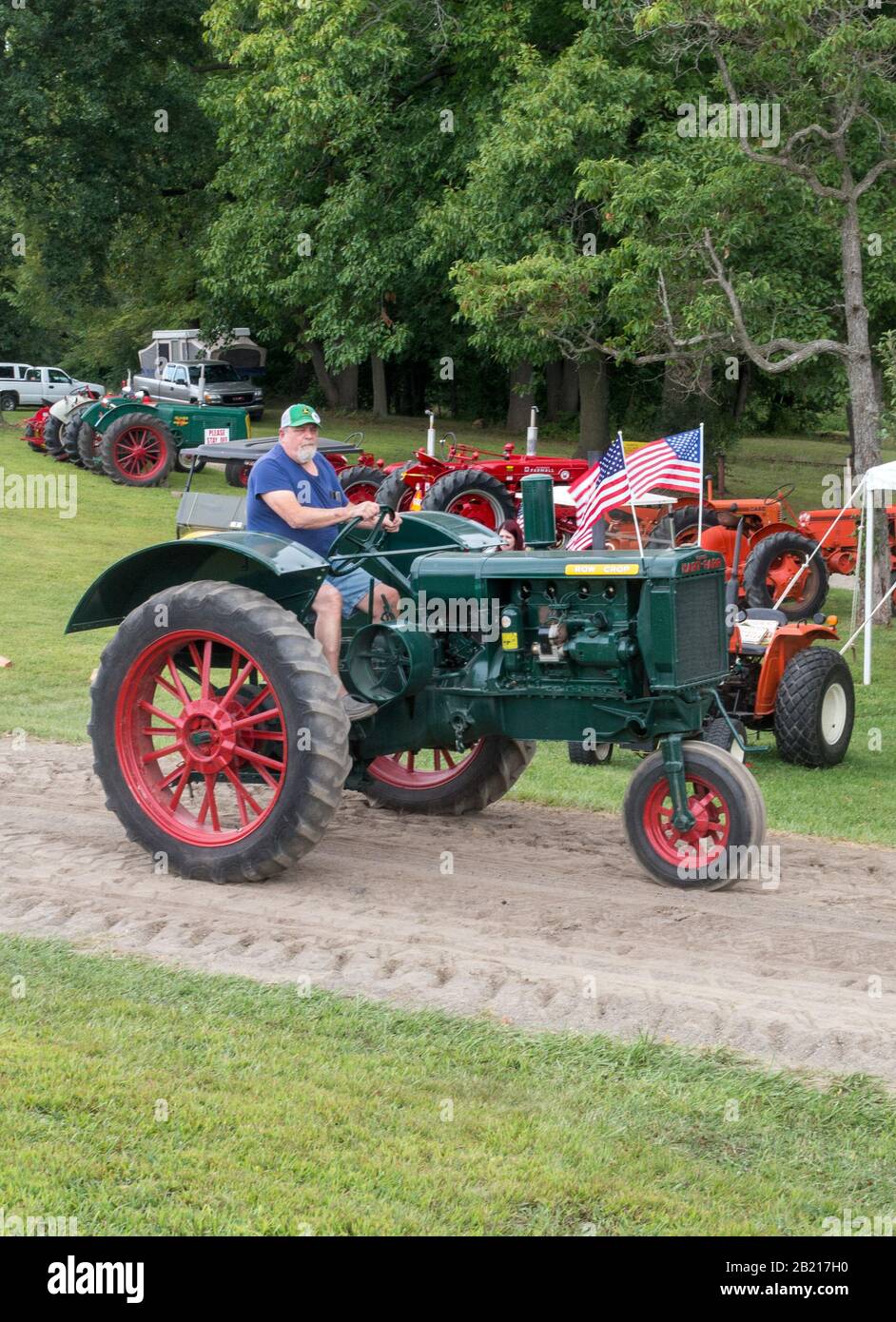 Hesston Indiana USA Aug 31 2019; a man drives a vintage tractor past rows of other antique tractors during the Hesston steam days show Stock Photo