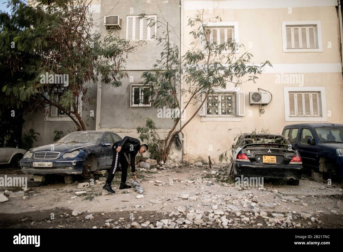 Tripoli, Libya. 28th Feb, 2020. A policeman inspects the damage around a building after a heavy shelling attack in Tripoli, Libya, on Feb. 28, 2020. The forces of the UN-backed Libyan government said on Friday that the rival east-based army attacked the Mitiga International Airport and its surroundings, as well as a number of residential neighborhoods, in Tripoli with heavy shelling. Credit: Amru Salahuddien/Xinhua/Alamy Live News Stock Photo