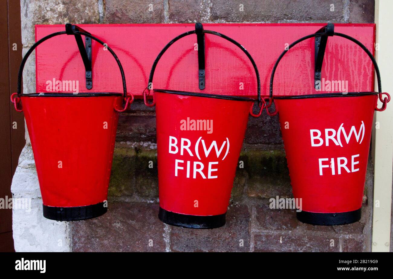 Old style fire buckets on the platform at Dunster railway station, West Somerset Railway, Dunster, Somerset, England Stock Photo