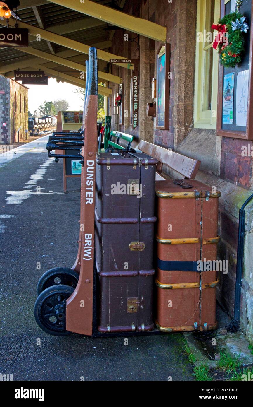 Old style luggage trunks on a trolley on the platform at Dunster railway station, West Somerset Railway, Dunster, Somerset, England Stock Photo