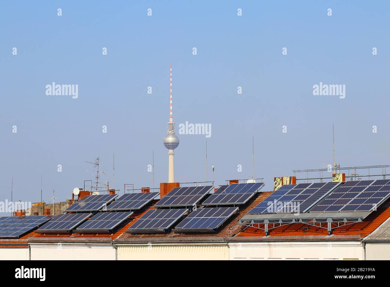 Green energy in Berlin Solar panels on the building, on the background TV tower Stock Photo
