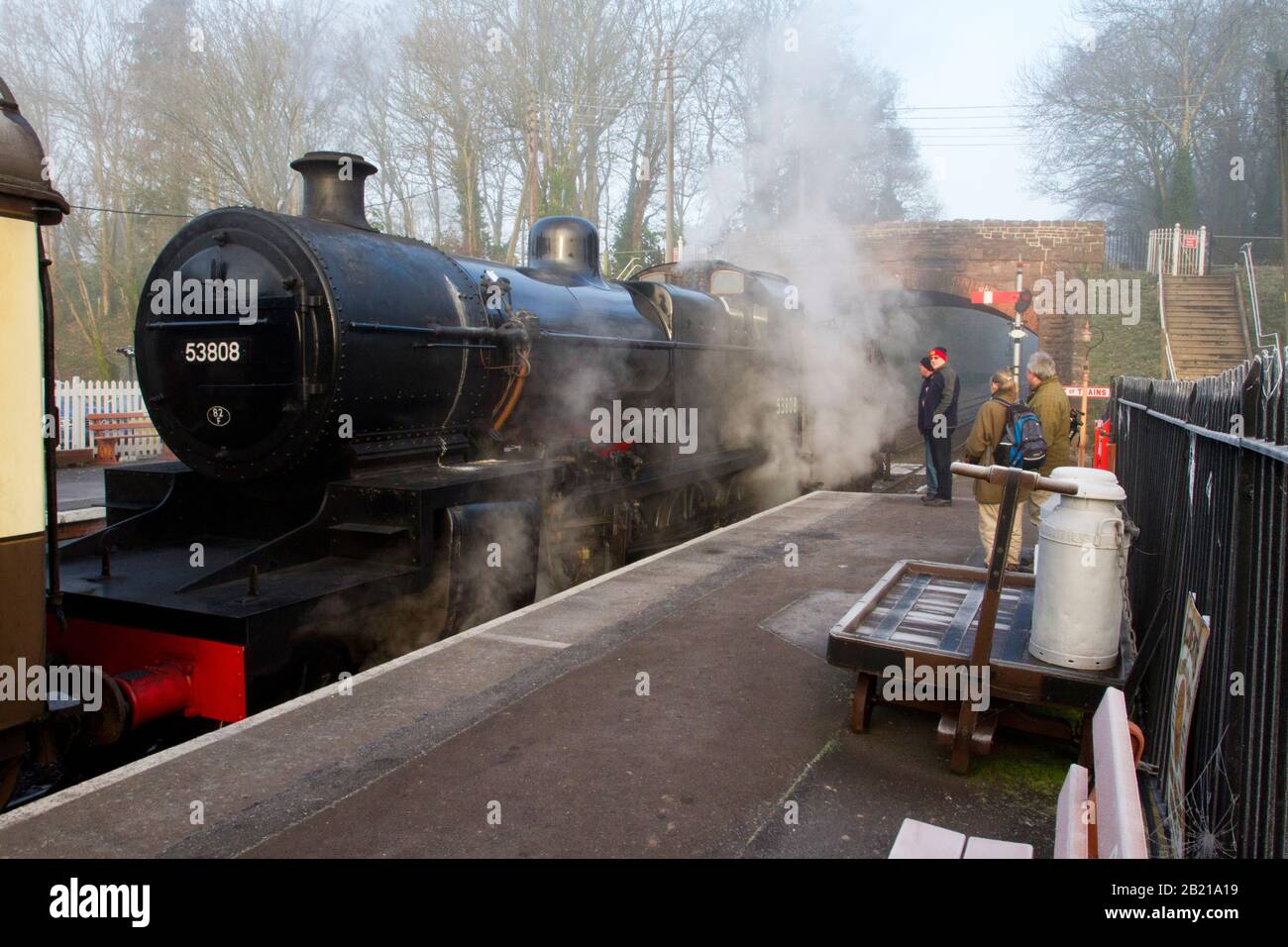 A working steam train at the platform at Bishops Lydeard station on the West Somerset Railway line with train enthusiasts chatting to the driver Stock Photo