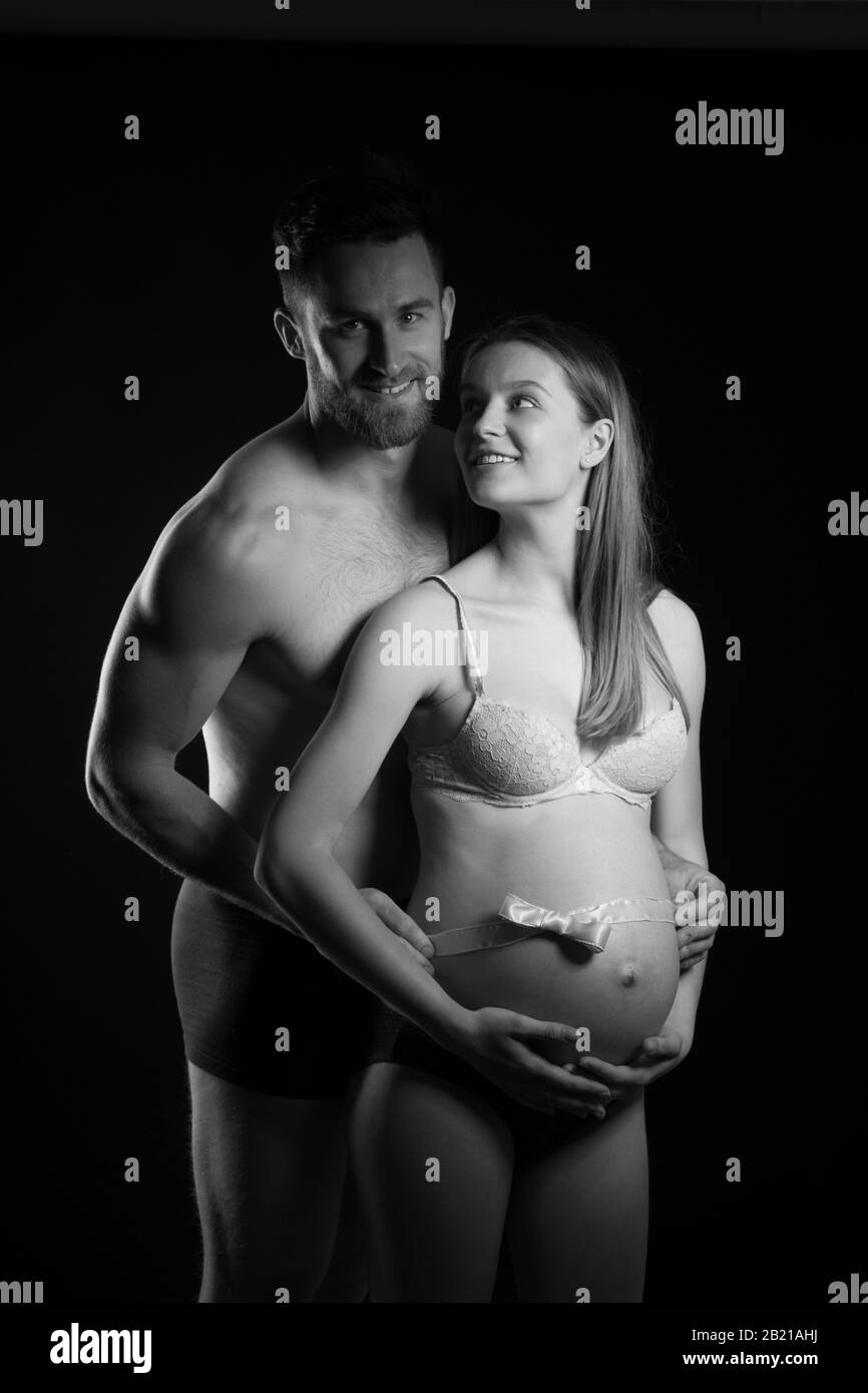 Pregnant woman and her man studio black and white photography Stock Photo