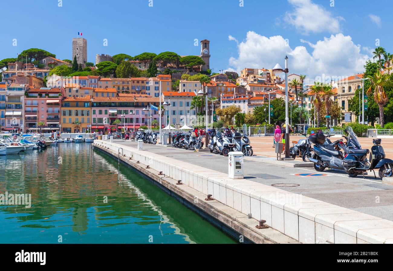 Cannes, France - August 14, 2018: Coastal view of Cannes at sunny summer day, ordinary people walk the street near old port Stock Photo
