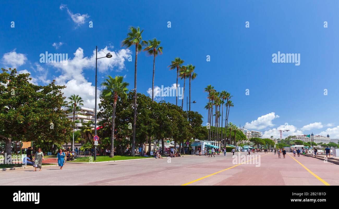 Cannes, France - August 14, 2018: People walk the Boulevard de la Croisette, street view of Cannes at sunny summer day Stock Photo