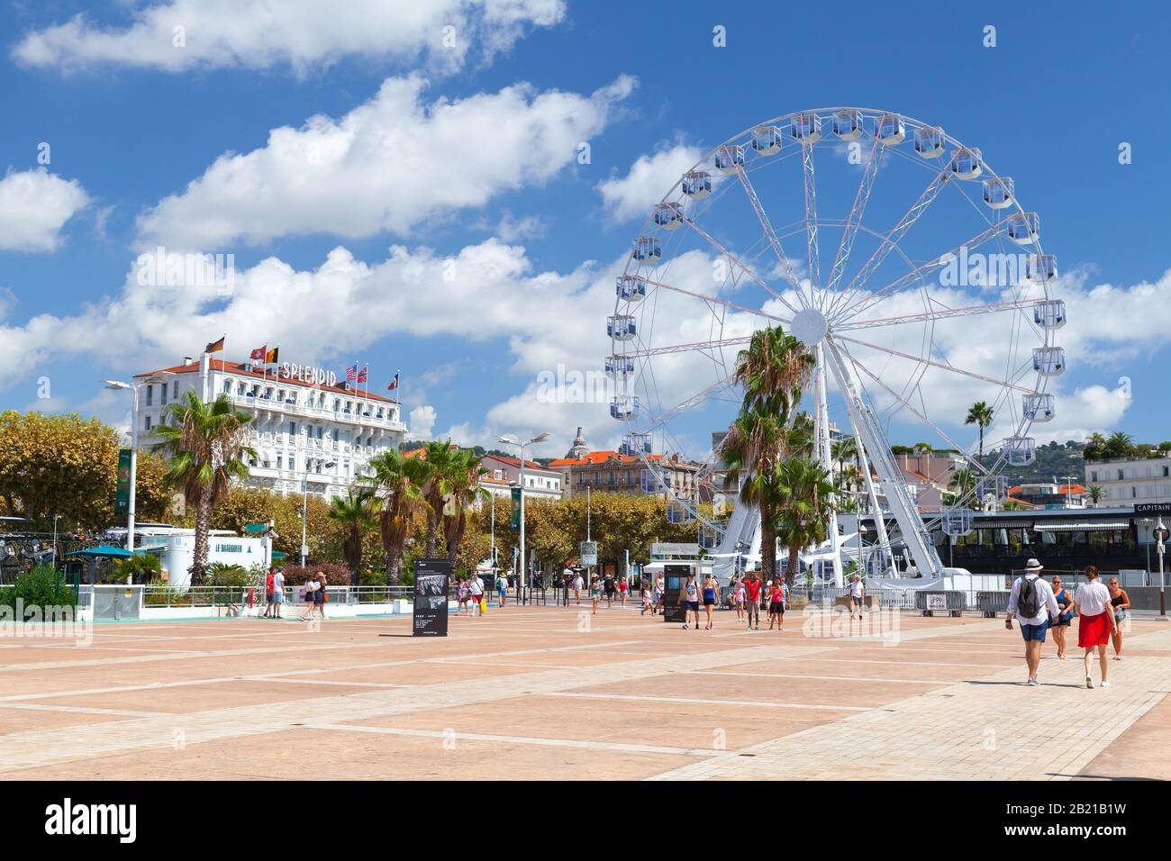 Cannes, France - August 14, 2018: Tourists walk at Esplanade Pantiero near Ferris wheel Stock Photo