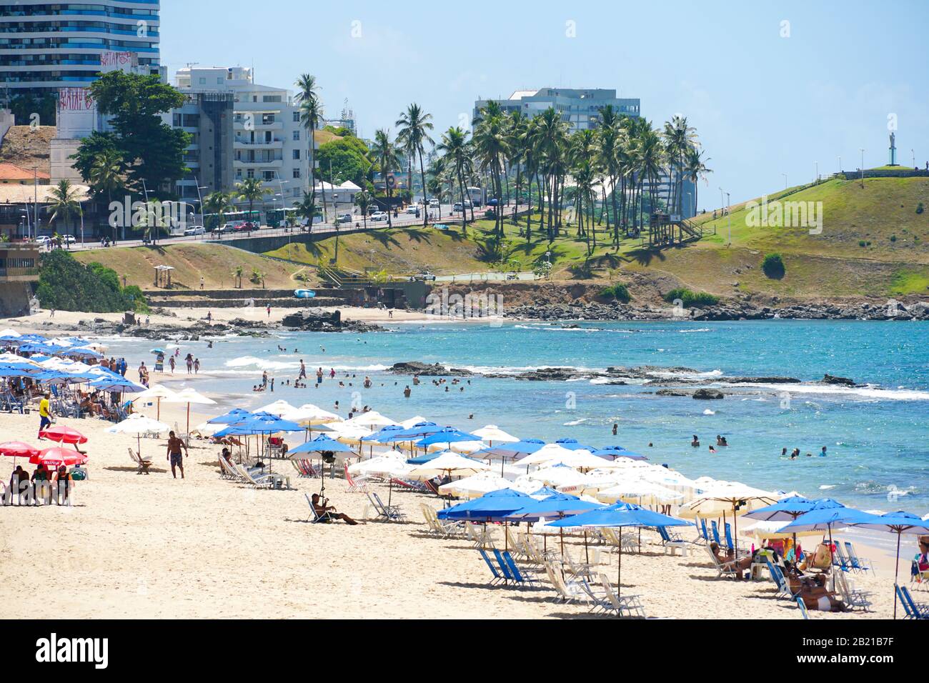 People enjoying sun, beach and blue water at Porto da Barra Beach next ...