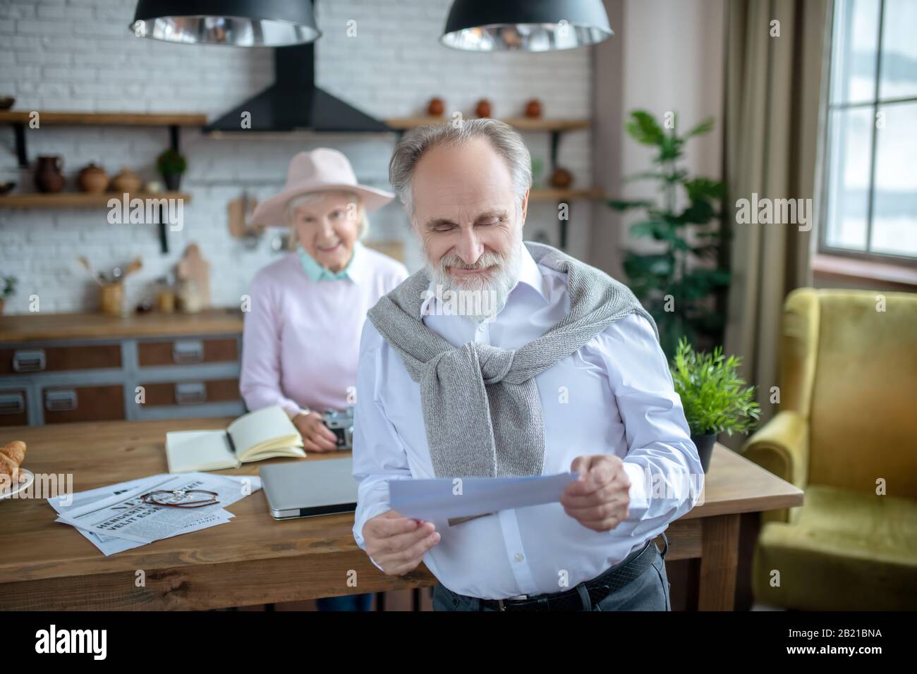 Smiling elderly man reading an important letter Stock Photo