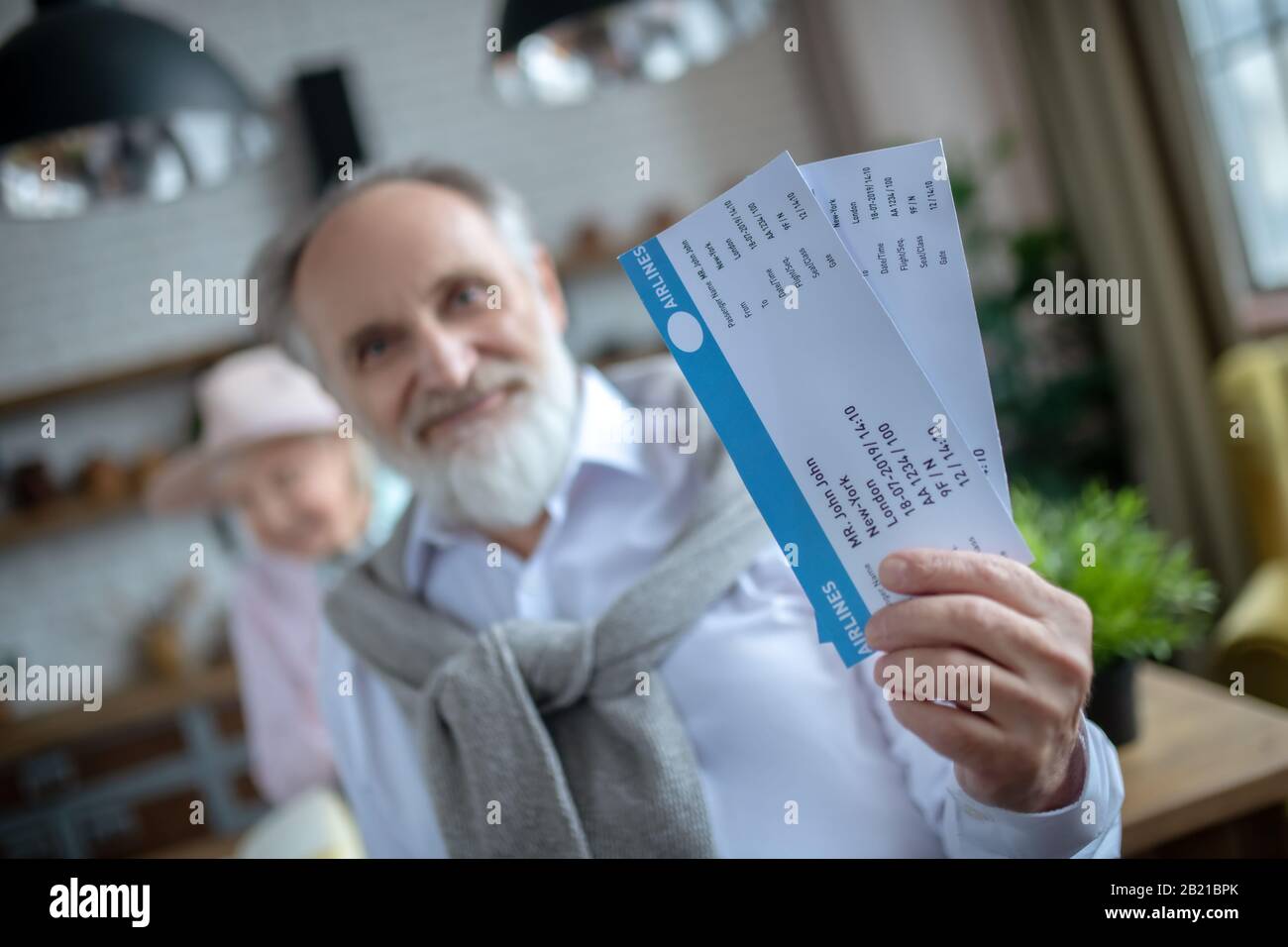Smiling elderly man holding two boarding passes Stock Photo