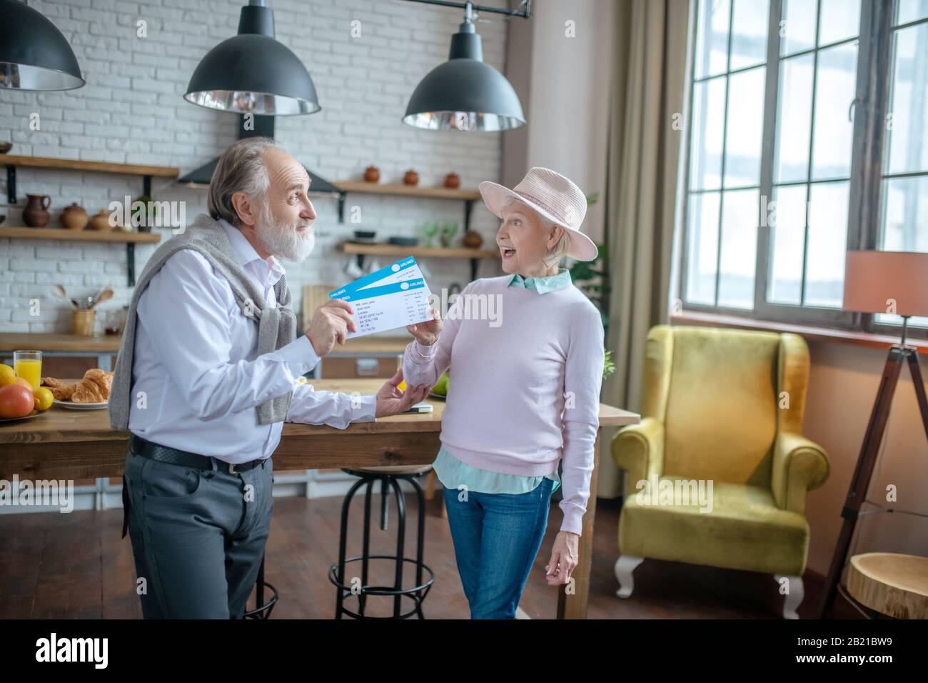 Senior man presenting boarding passes to his wife Stock Photo