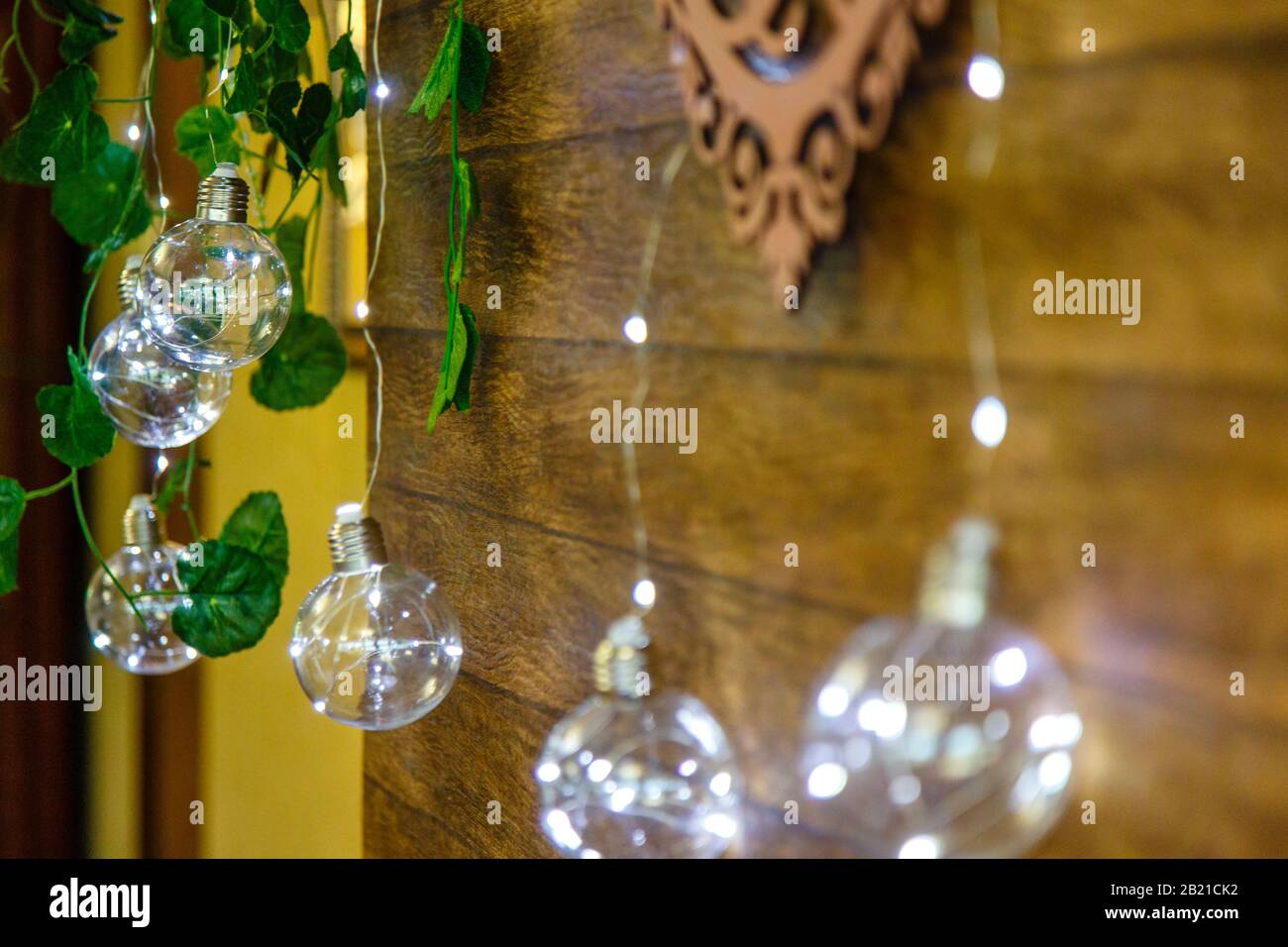Decorative light bulbs-garlands on the background of a wooden wall. Stock Photo