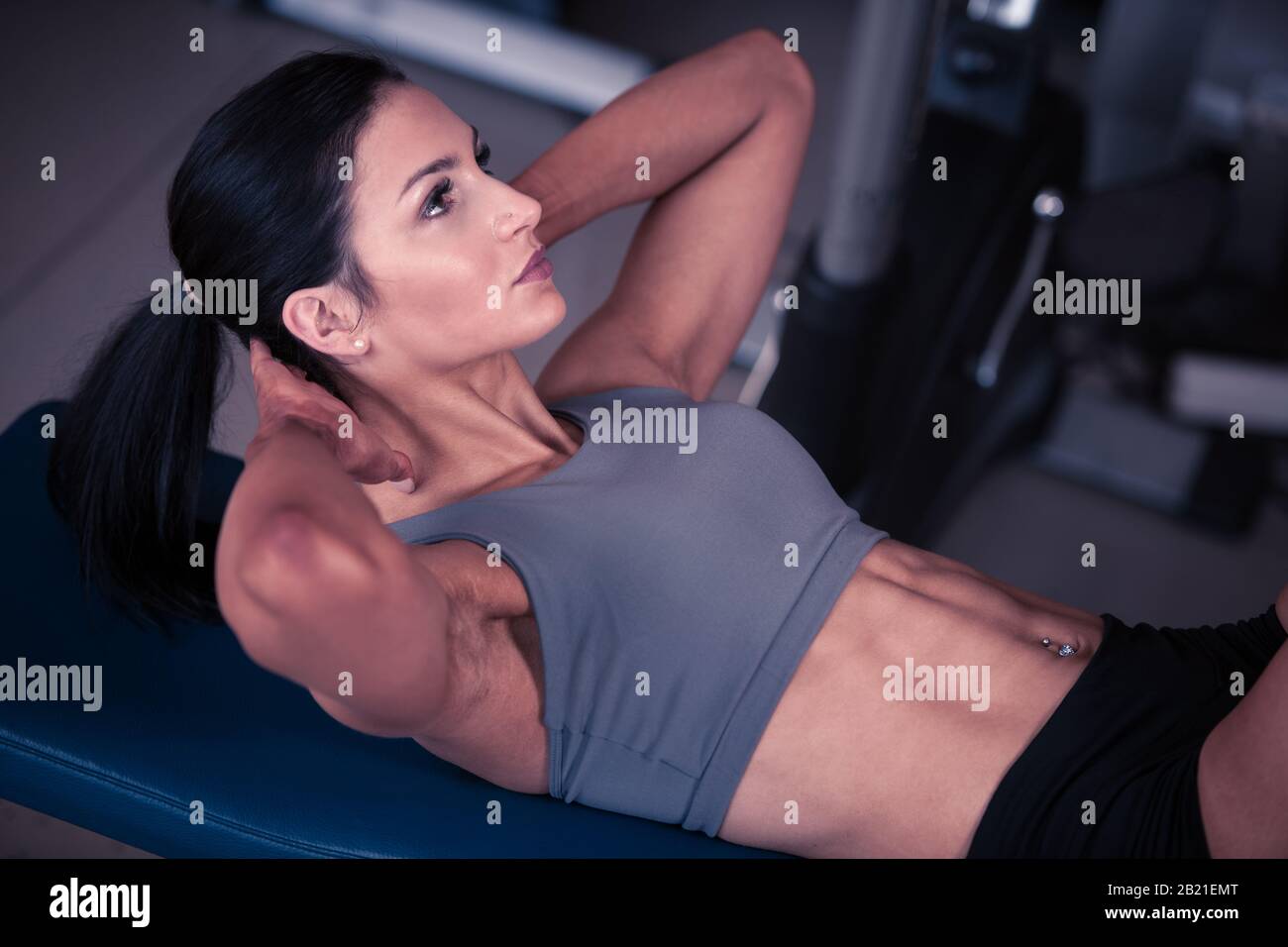 Beautiful young fit woman workout abdominal muscles abs in fitness gym ...