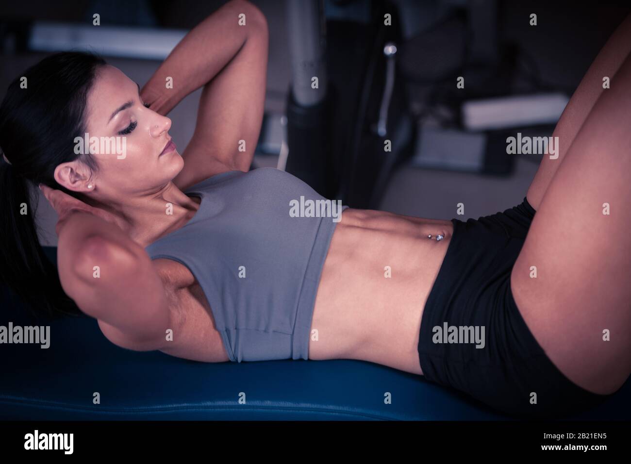 Beautiful young fit woman workout abdominal muscles abs in fitness gym ...