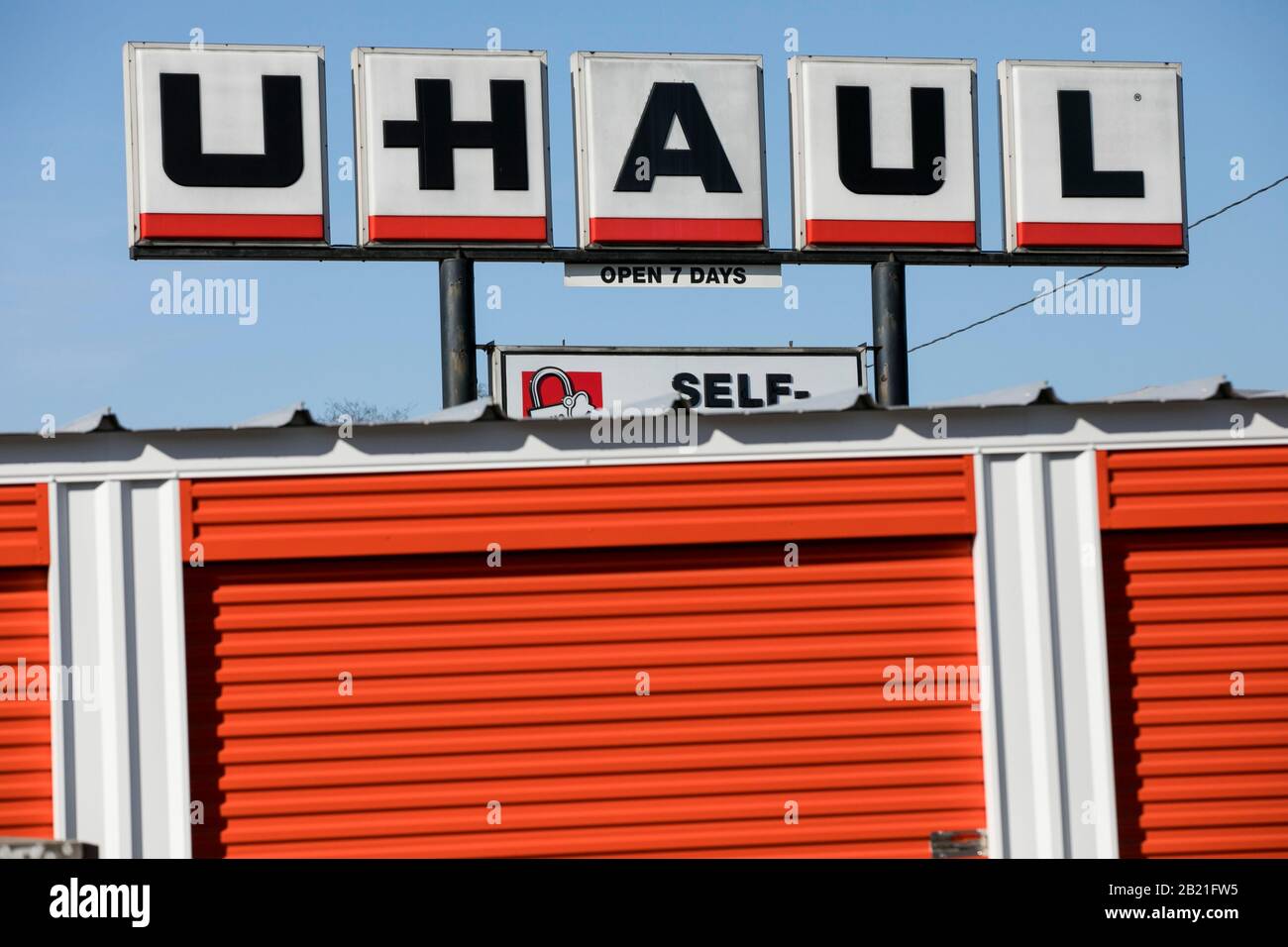 A logo sign and moving trucks outside of a U-Haul location in Baltimore, Maryland on February 22, 2020. Stock Photo