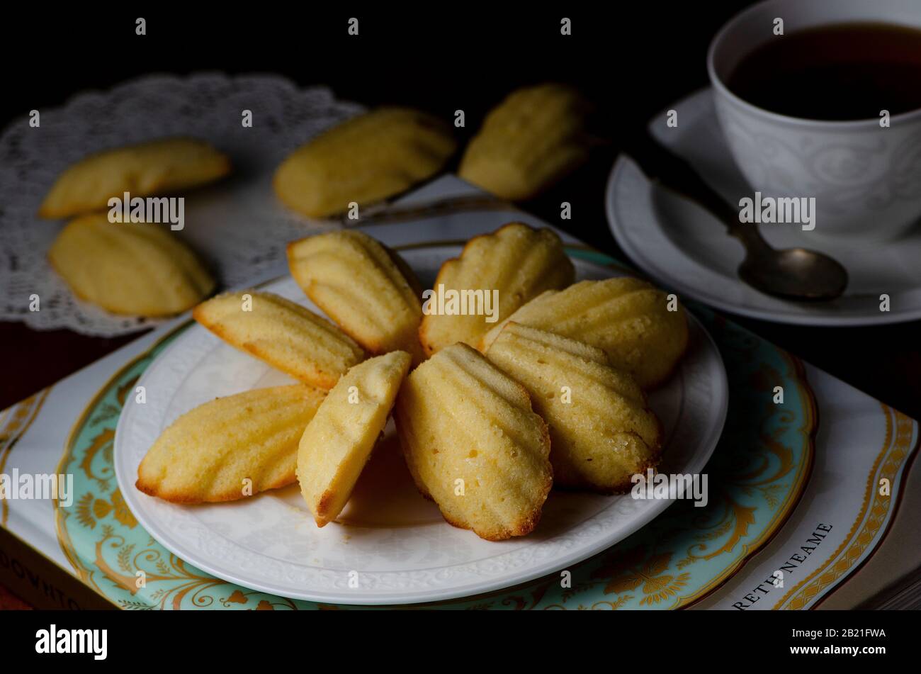 Traditional French Madeleines with cup of tea on dark wooden background Stock Photo