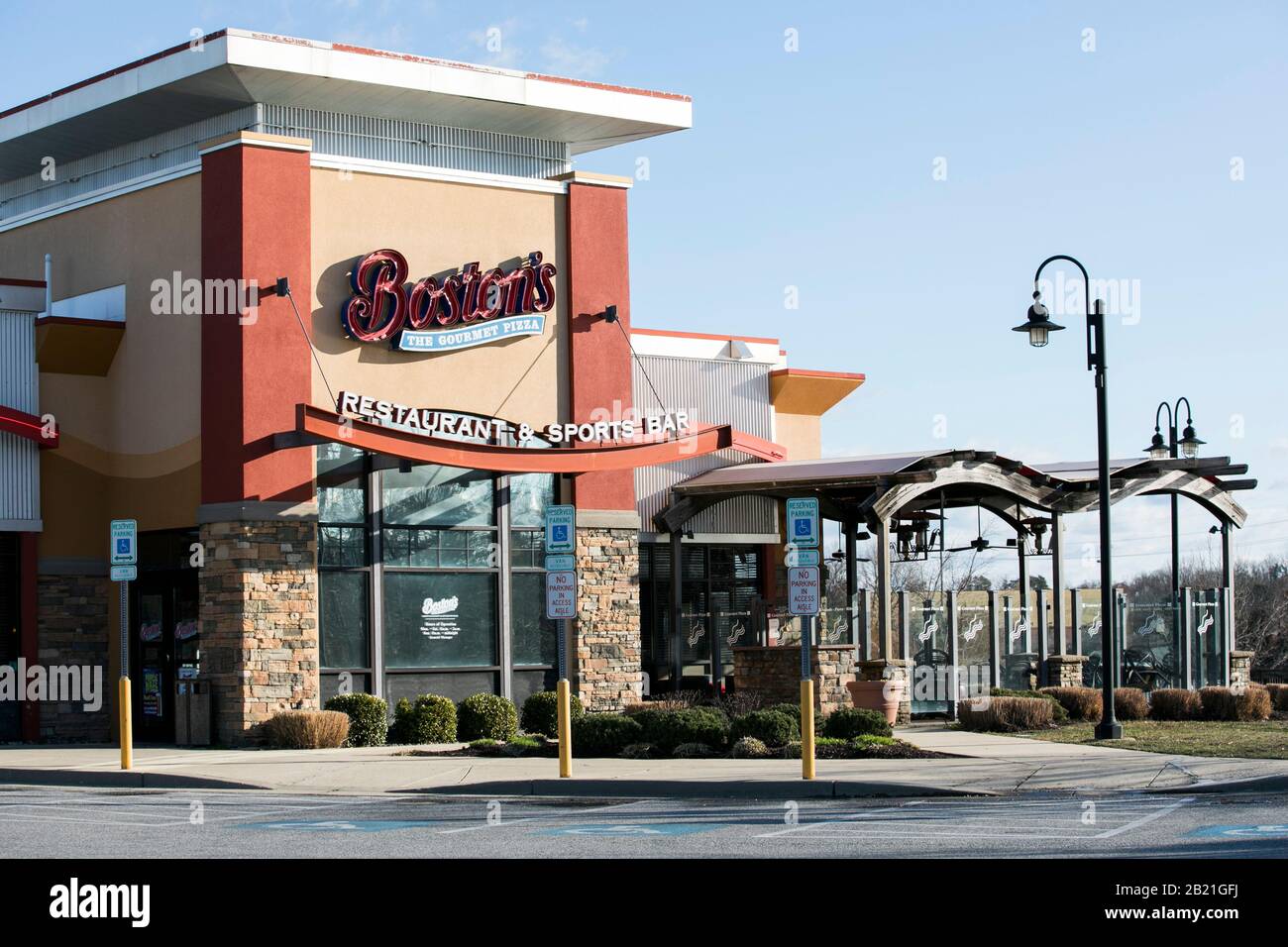 A logo sign outside of a Boston Pizza, Boston's The Gourmet Pizza