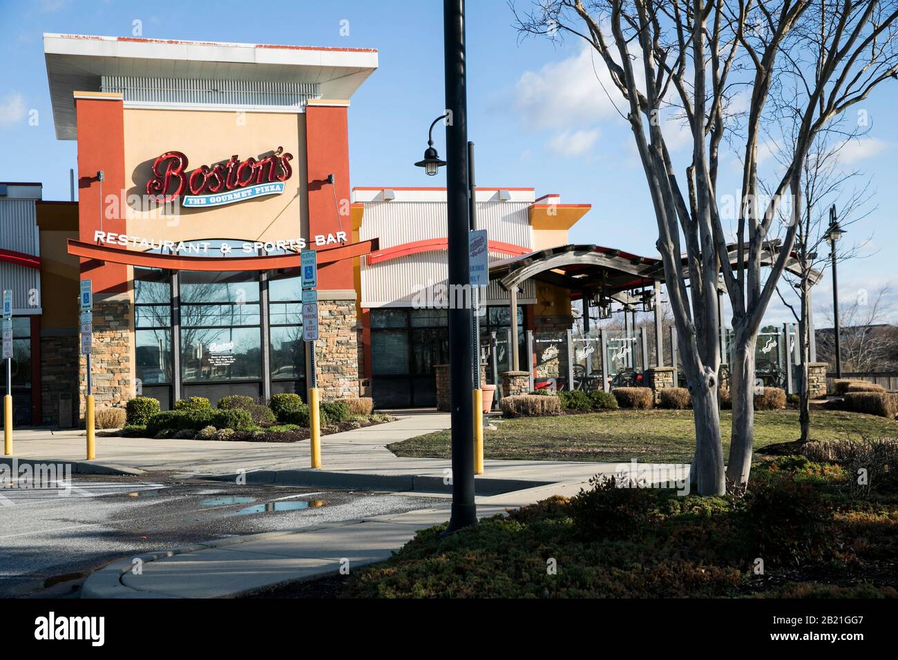 A logo sign outside of a Boston Pizza, Boston's The Gourmet Pizza