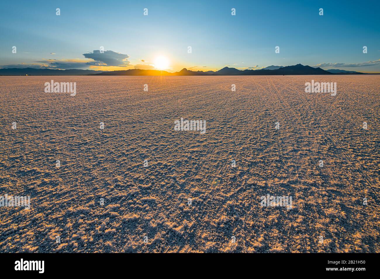 Bonneville Salt Flats blue yellow colorful landscape sunset near Salt Lake City, Utah and silhouette view of mountains and sun setting behind clouds Stock Photo