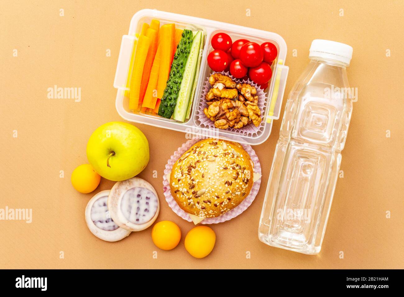 School lunch box with sandwich, vegetables, water, and fruits on table.  Healthy eating habits concept Stock Photo - Alamy