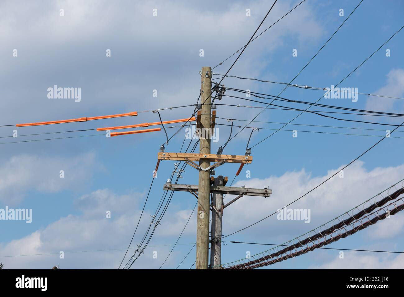 A sequence of images of a wooden electrical utility pole being replaced, taken over the course of several days. Stock Photo