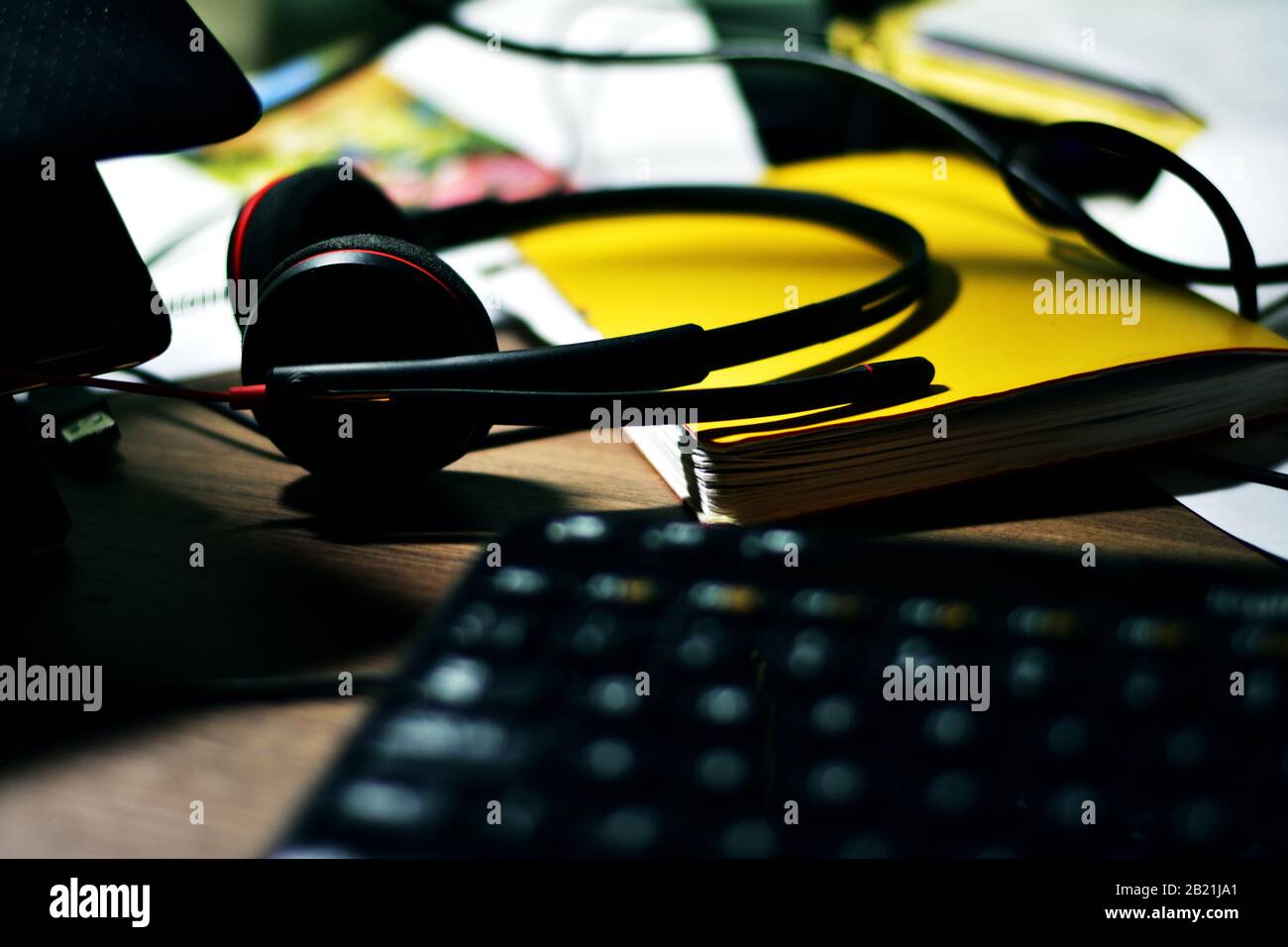 Messy desktop with headset and keyboard Stock Photo
