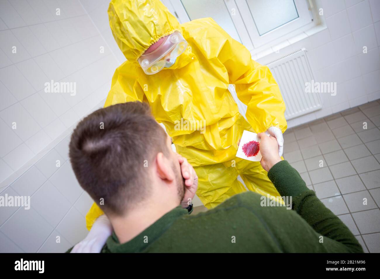 Woman in a yellow full protected suit on a patient Stock Photo