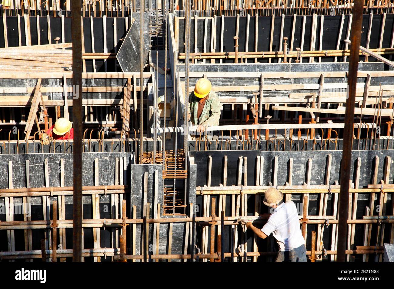 workers in the construction site making reinforcement metal framework ...