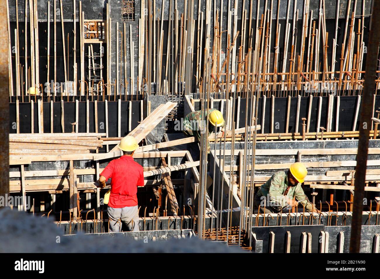 workers in the construction site making reinforcement metal framework ...
