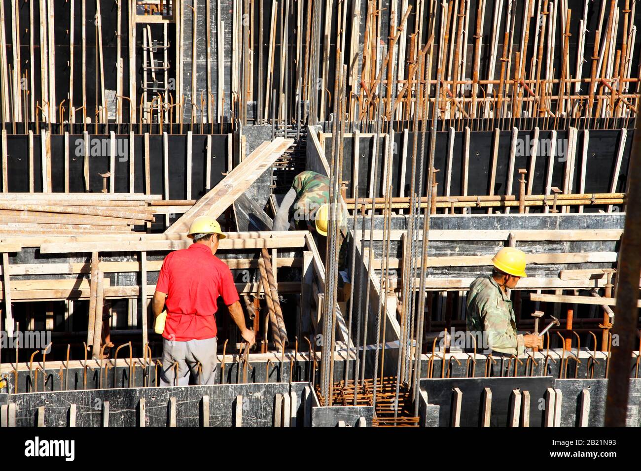 workers in the construction site making reinforcement metal framework ...