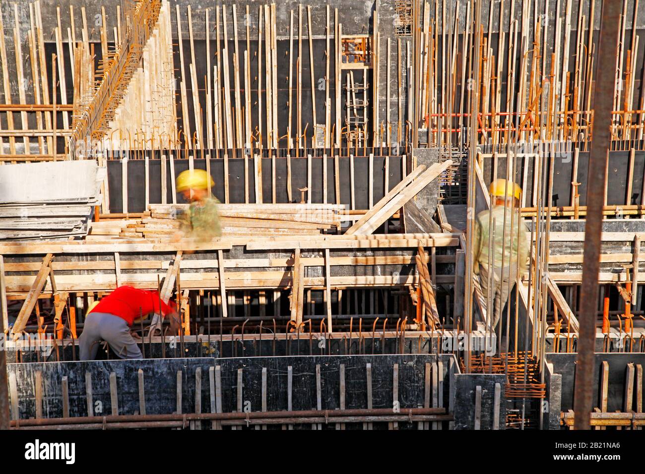 workers in the construction site making reinforcement metal framework ...