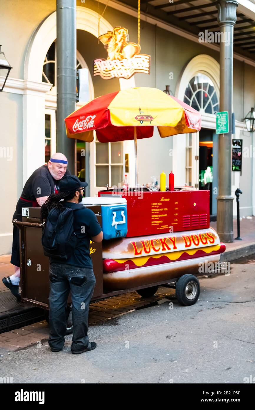 New Orleans, USA - April 22, 2018: Lucky Dogs hot dog stall stand cart on Bourbon street with people and vendor in evening Stock Photo