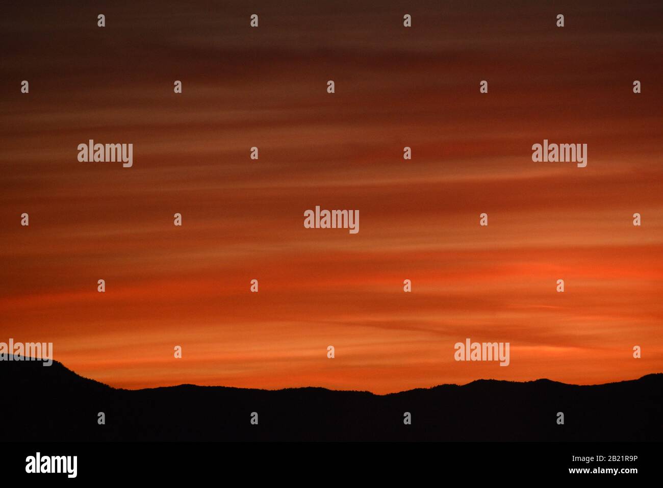 Orange sunset over silhouette mountains in Arizona Stock Photo
