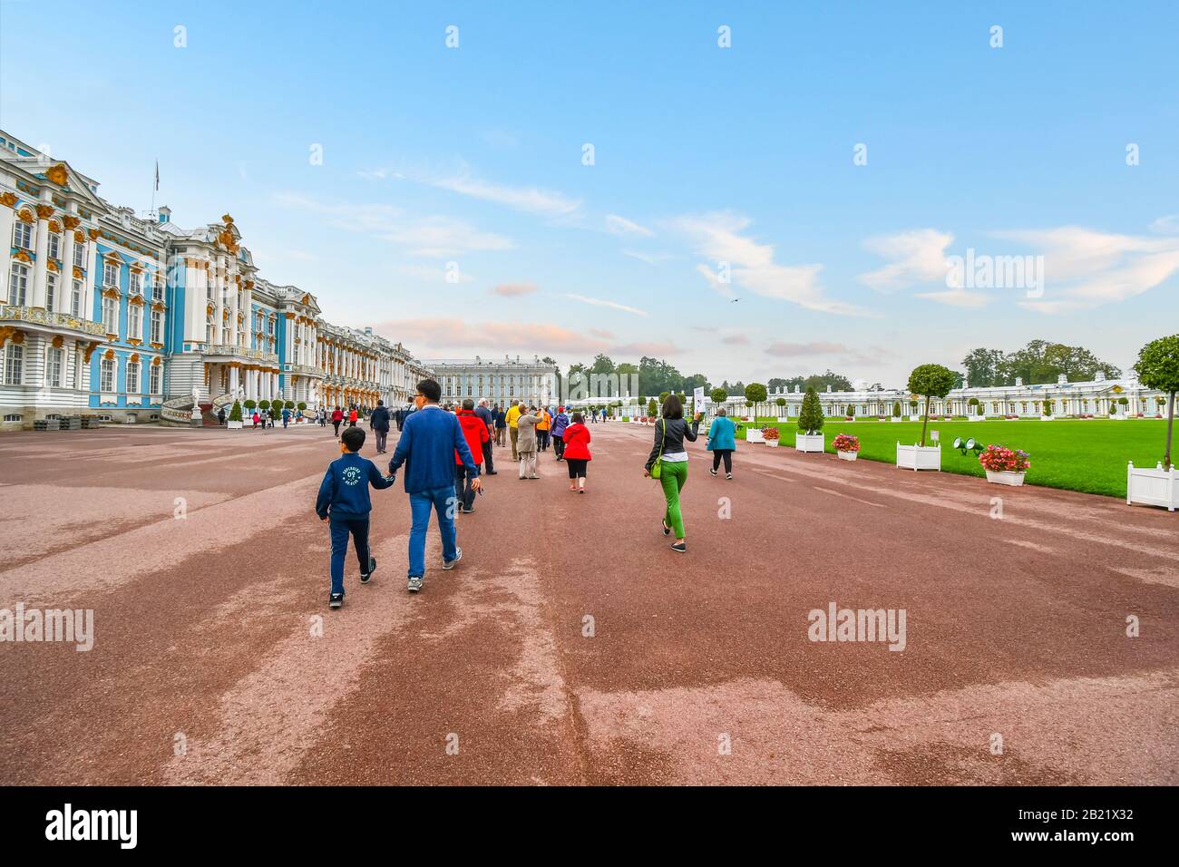 Tourists walk across the large promenade in between Catherine Palace and Gardens in Tsarskoye Selo, near St. Petersburg, Russia. Stock Photo