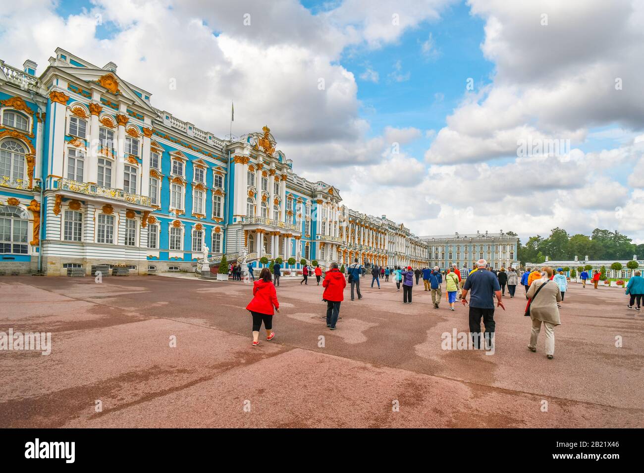 Tourists walk across the large promenade in between Catherine Palace and Gardens in Tsarskoye Selo, Pushkin, near St. Petersburg, Russia. Stock Photo