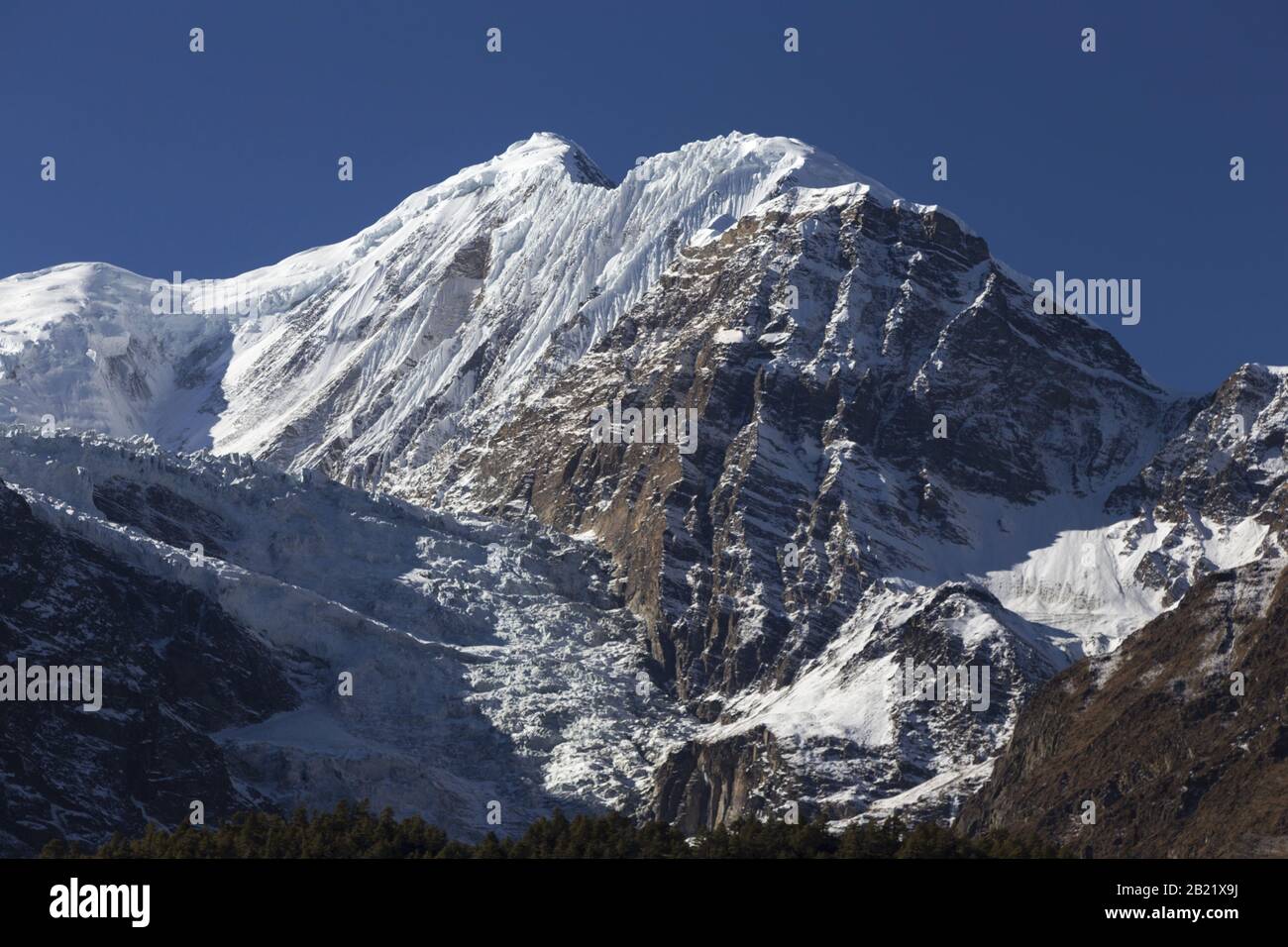 Snowy Ganggapurna Mountain Peak Range and Glacier Landscape View above Manang Village in Nepal Himalaya Mountains on Annapurna Circuit Hiking Trek Stock Photo