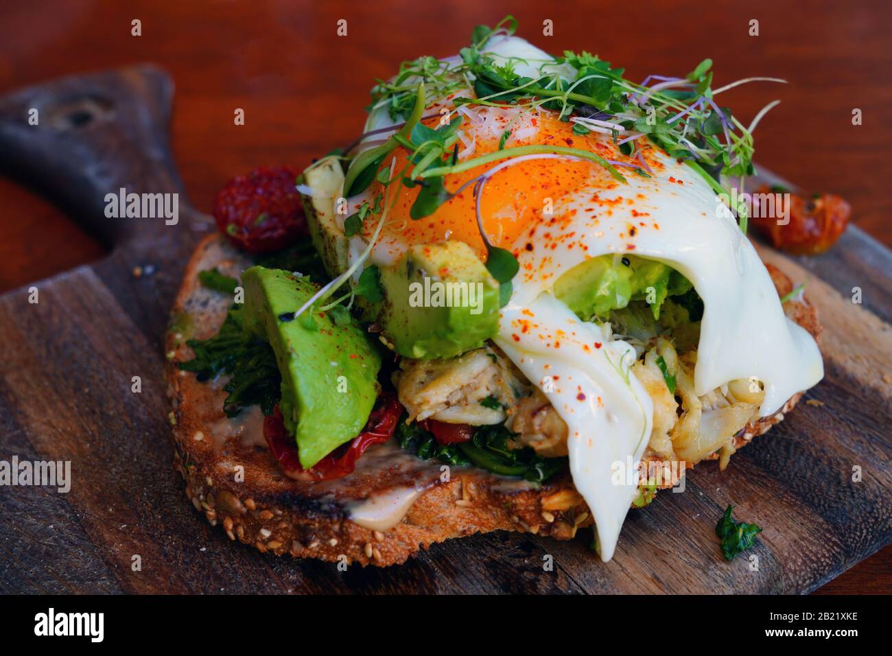 Multigrain avocado toast with fried egg on top Stock Photo Alamy