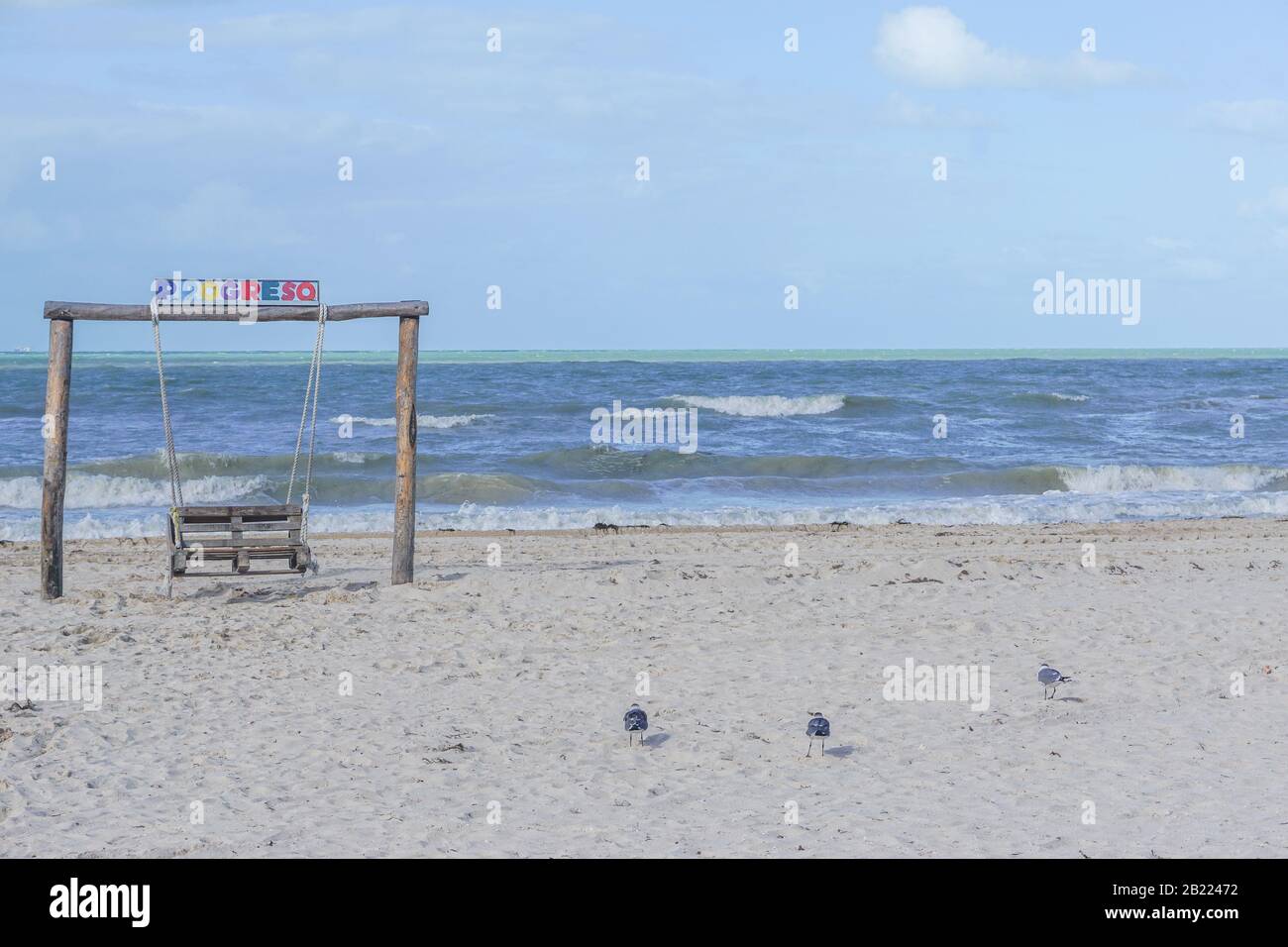 Progreso, Yucatan, Mexico: An empty wooden swing with 'PROGRESO' written in colorful letters, on a beach on the Gulf of Mexico. Stock Photo