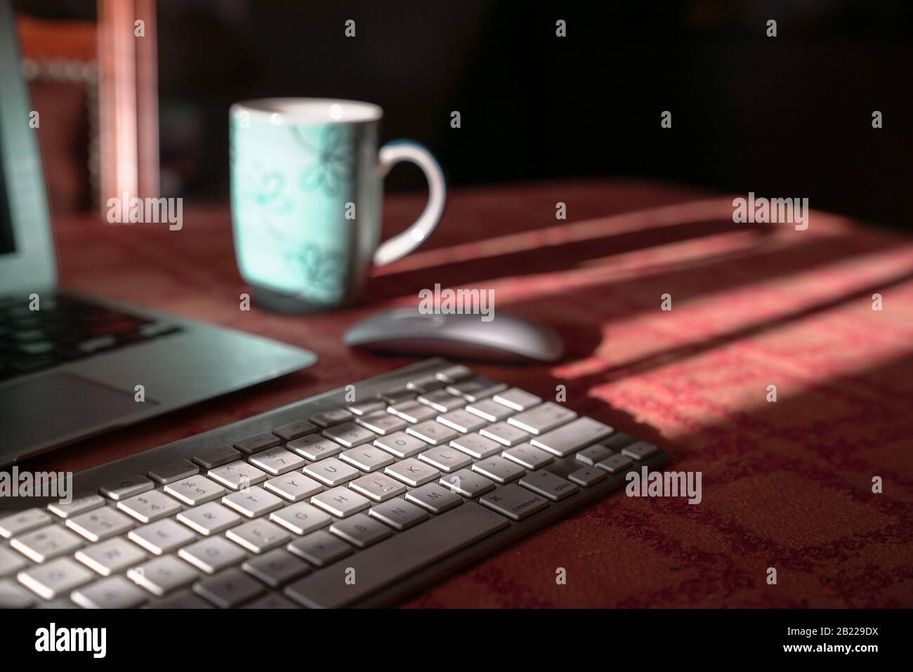 Laptop with wireless keyboard and mouse and coffee in cup. Work from home or technology concept. Stock Photo
