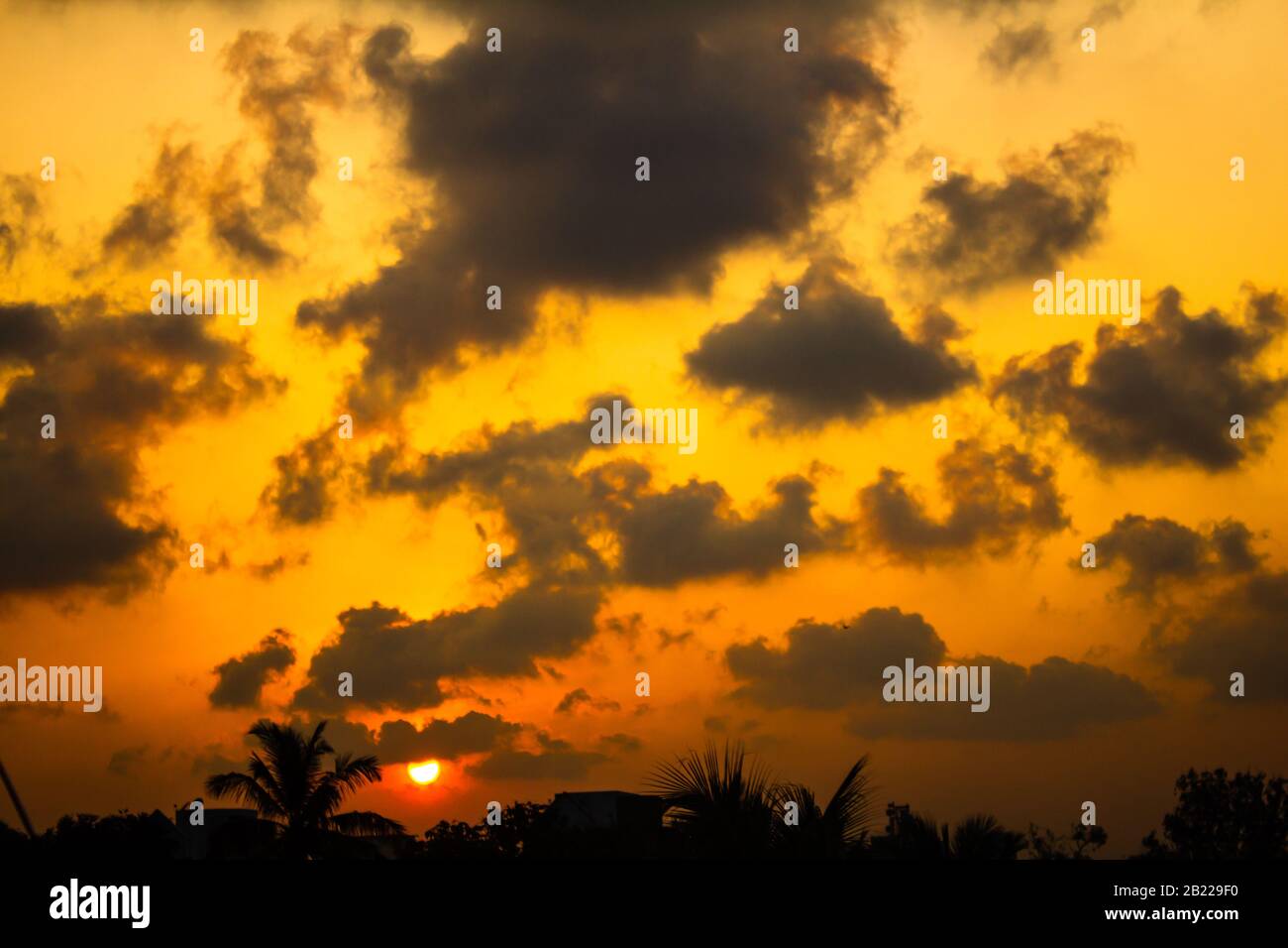 Scenic view of the sky with dark clouds during sunset in cityscape ...